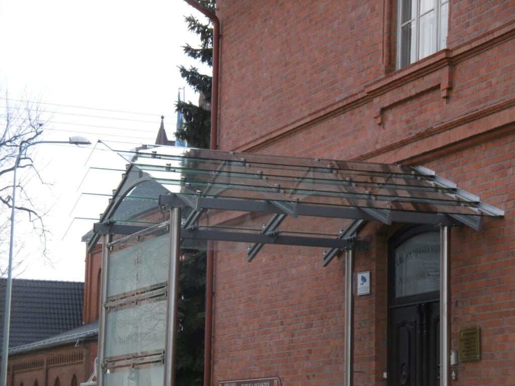 szklane daszki nad drzwi na dom z cegły